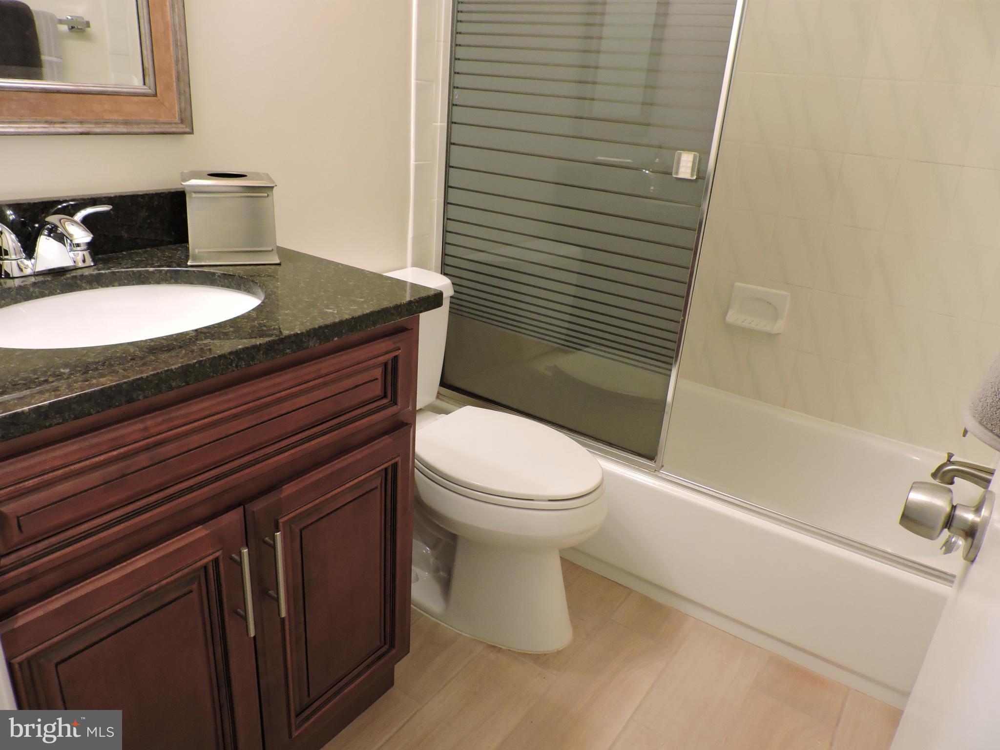 5011 Roslyn Road Annandale, VA 22003 - Photo 20 of 28 a bathroom with a granite countertop toilet sink and mirror