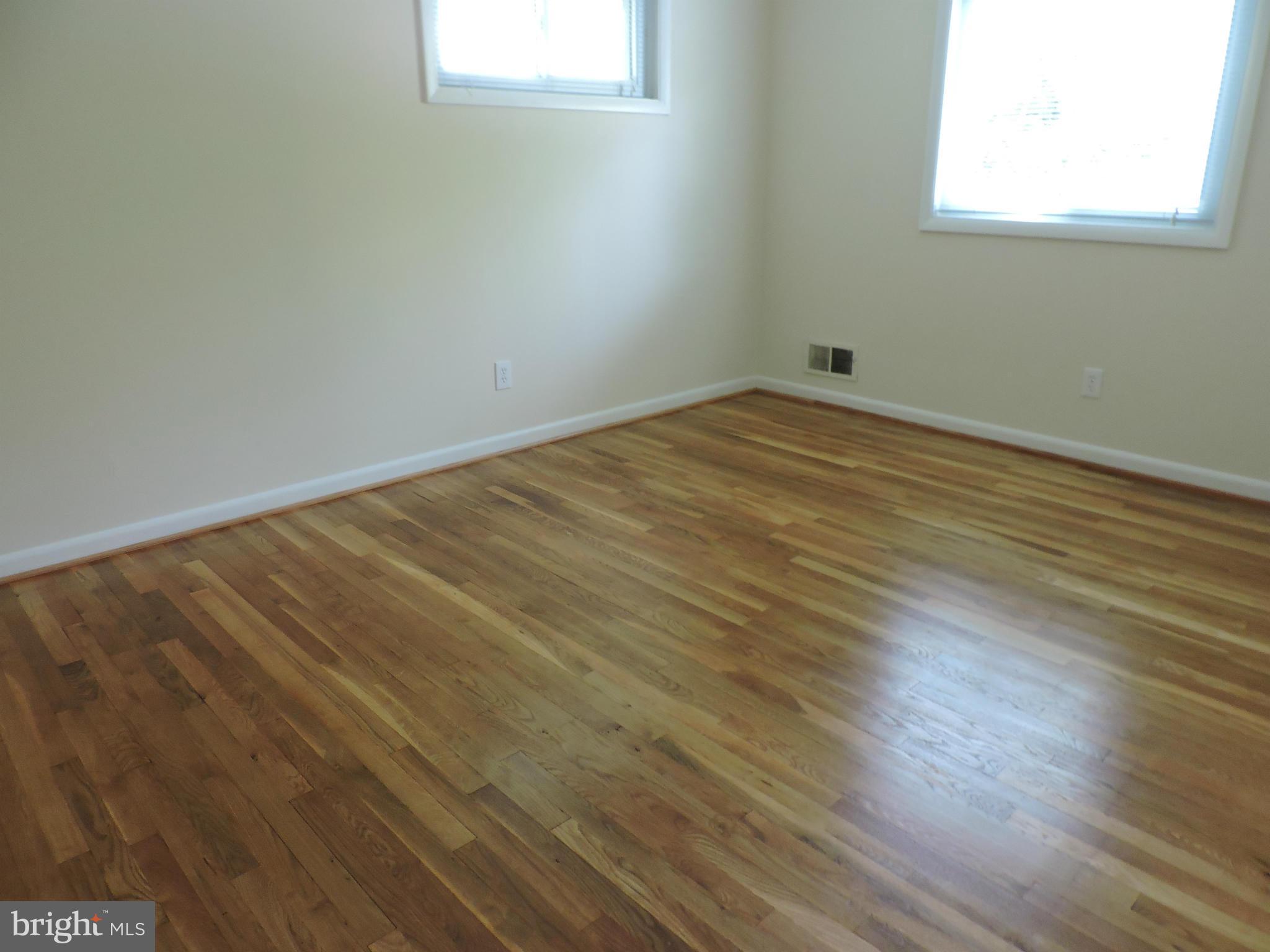 5011 Roslyn Road Annandale, VA 22003 - Photo 22 of 28 an empty room with wooden floor and windows
