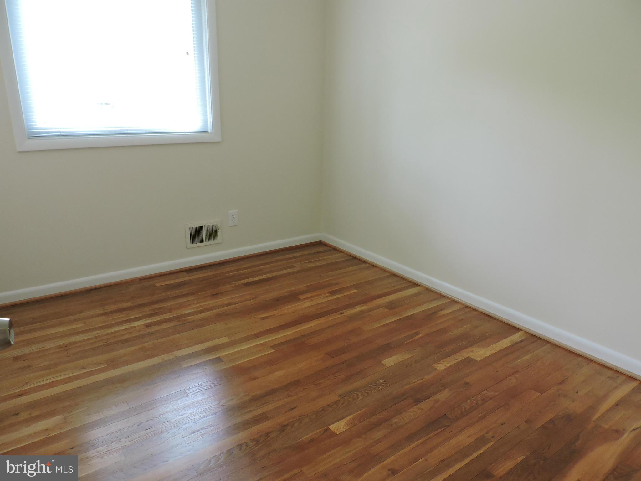 5011 Roslyn Road Annandale, VA 22003 - Photo 24 of 28 an empty room with wooden floor and windows