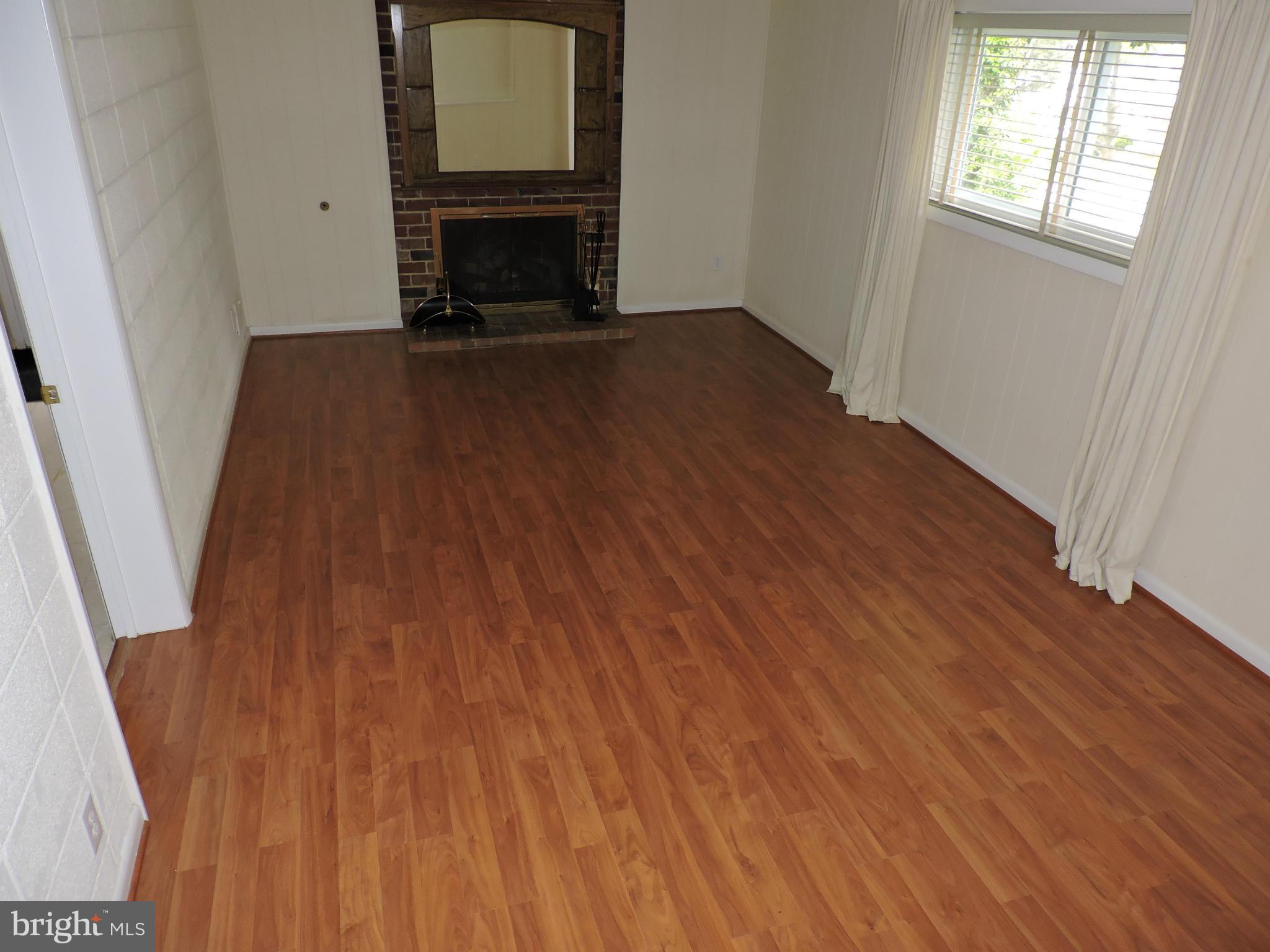 5011 Roslyn Road Annandale, VA 22003 - Photo 26 of 28 an empty room with wooden floor fireplace and windows