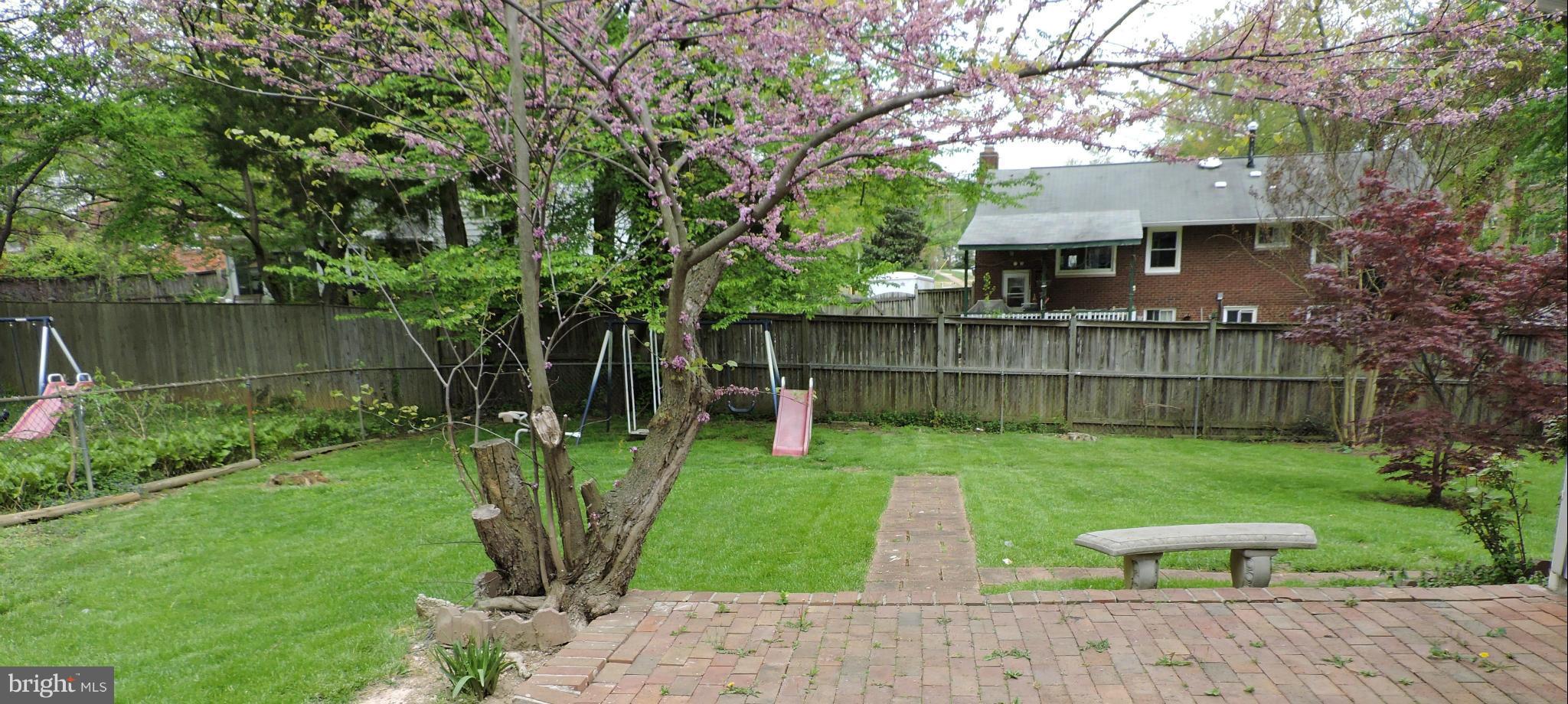 5011 Roslyn Road Annandale, VA 22003 - Photo 27 of 28 a view of a backyard with table and chairs a barbeque and a large tree