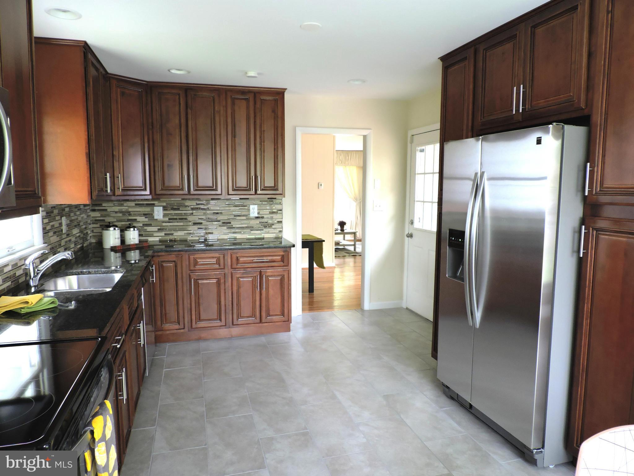 5011 Roslyn Road Annandale, VA 22003 - Photo 8 of 28 a kitchen with granite countertop a refrigerator stove and sink