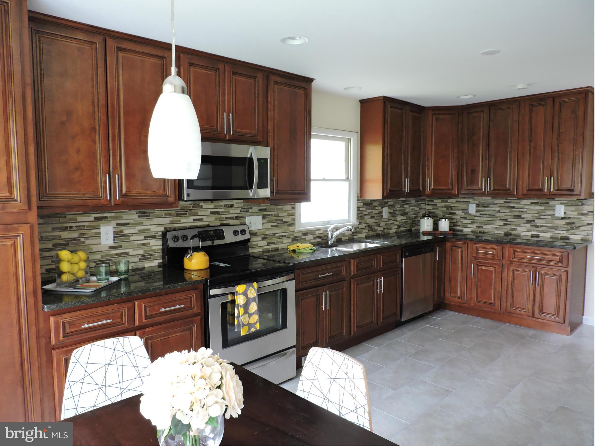 5011 Roslyn Road Annandale, VA 22003 - Photo 9 of 28 a kitchen with granite countertop a stove a sink dishwasher and cabinets with wooden floor