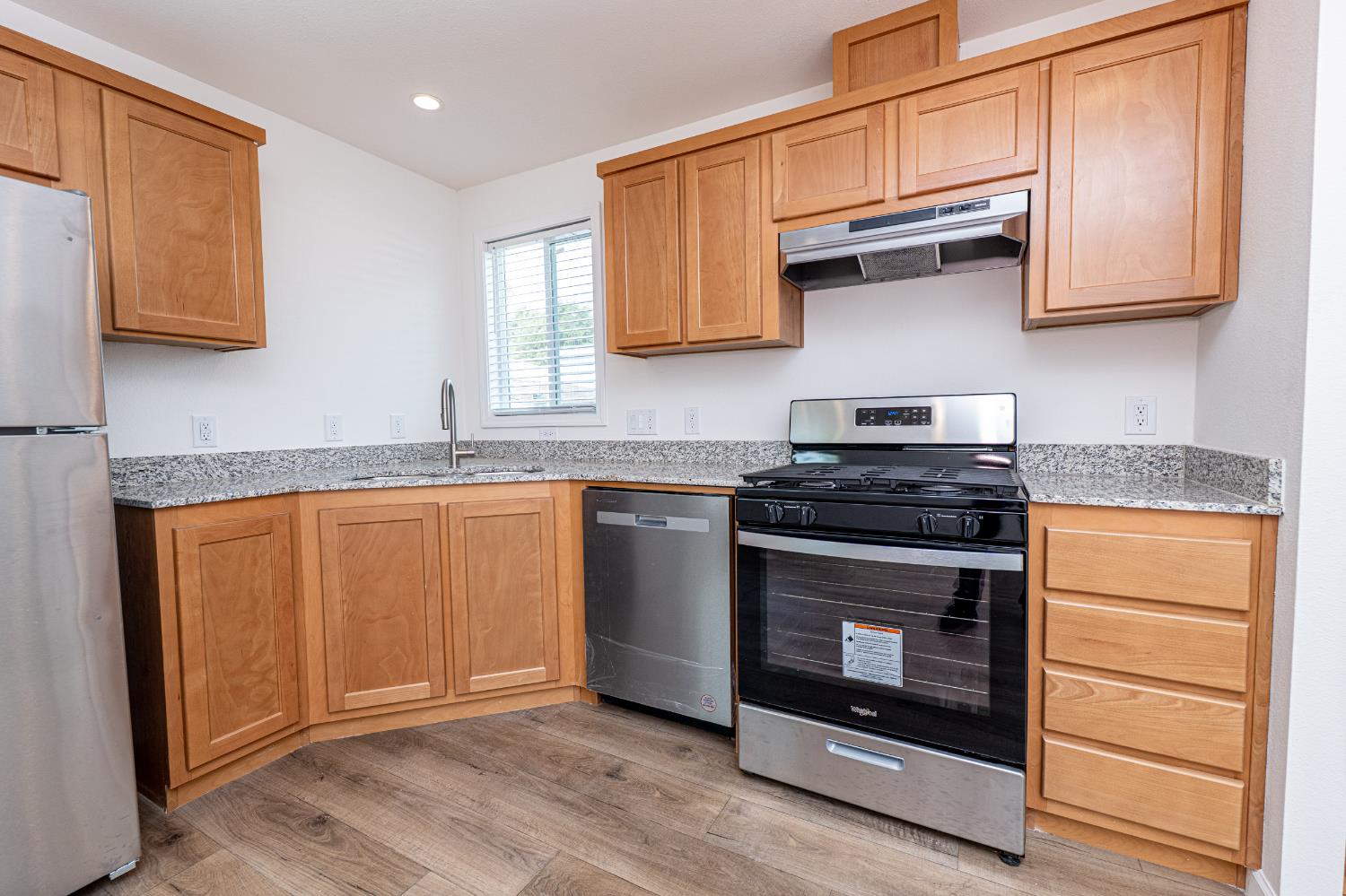6540 Virginiatown Road, Unit 30 Newcastle, CA 95658 - Photo 6 of 24 a kitchen with granite countertop wooden cabinets and a stove