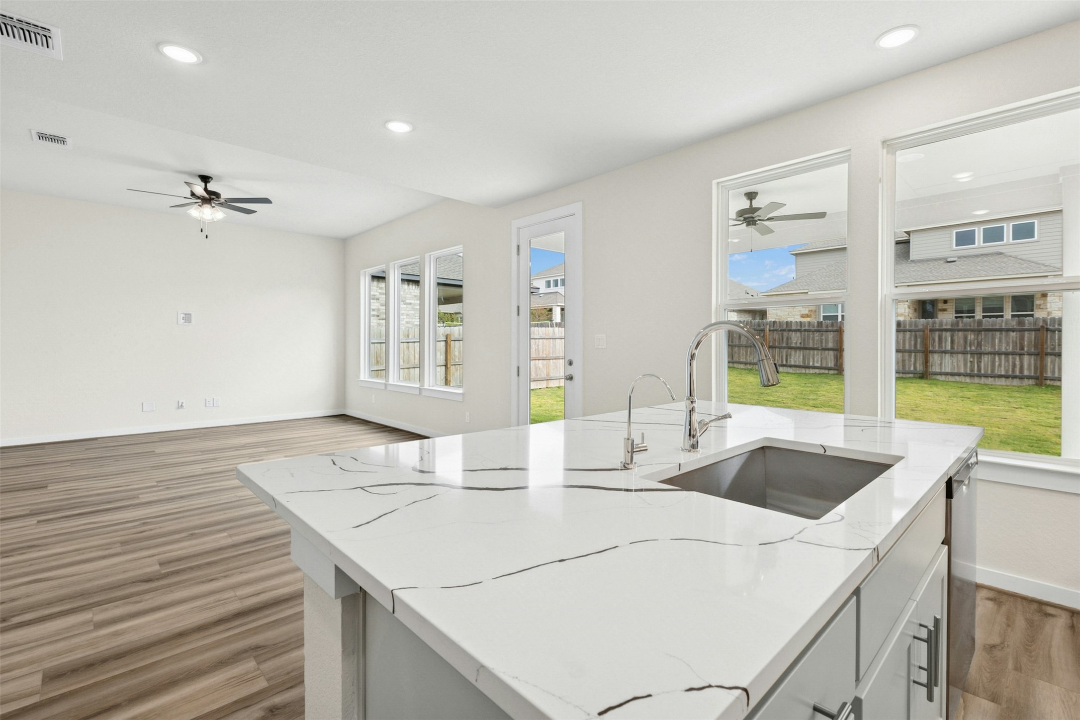 4313 Contrail Lane Round Rock, TX 78665 - Photo 11 of 32 a kitchen with a sink dishwasher and a stove with wooden floor
