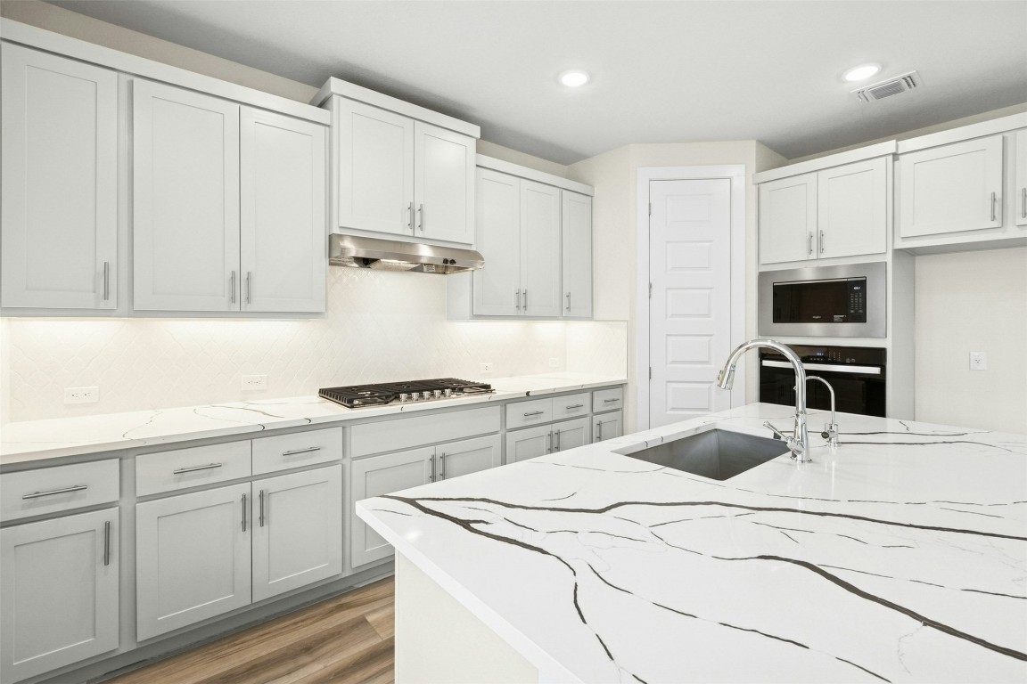 4313 Contrail Lane Round Rock, TX 78665 - Photo 8 of 32 a kitchen with white cabinets and appliances