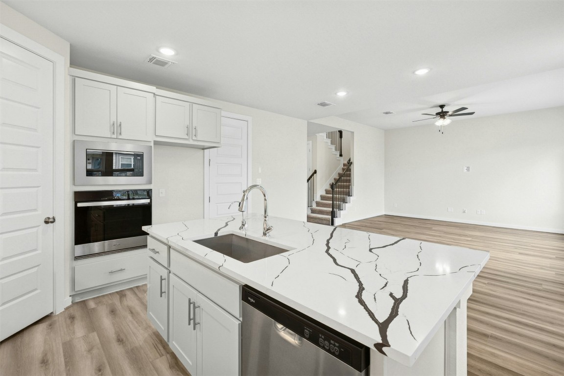 4313 Contrail Lane Round Rock, TX 78665 - Photo 9 of 32 a kitchen with stainless steel appliances a sink a stove a refrigerator and cabinets