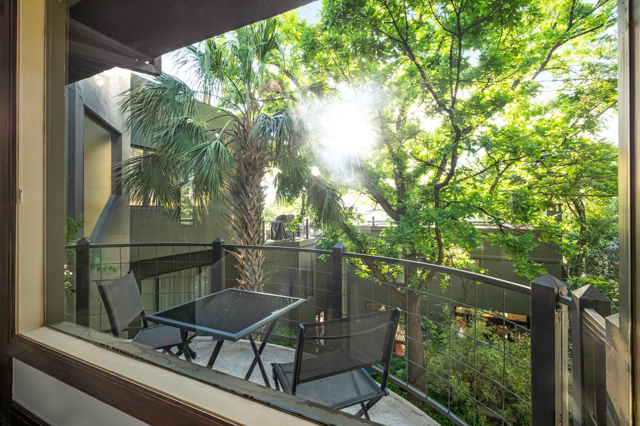 1111 West 12th Street, Unit 107 Austin, TX 78703 - Photo 20 of 38 Balcony featuring a metal railing and mature tree canopy