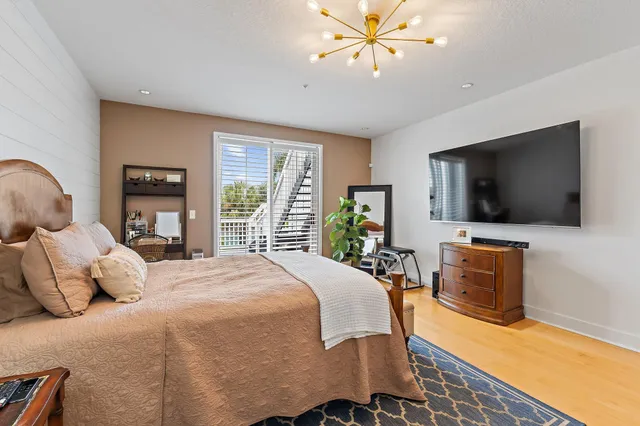 a bedroom with a bed and a flat screen tv on dresser
