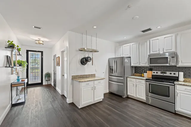 a kitchen with white cabinets and stainless steel appliances