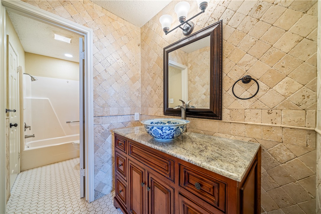 3052 Quail Springs Road, Unit A3 Corpus Christi, TX 78414 - Photo 21 of 27 a bathroom with a granite countertop sink and a mirror
