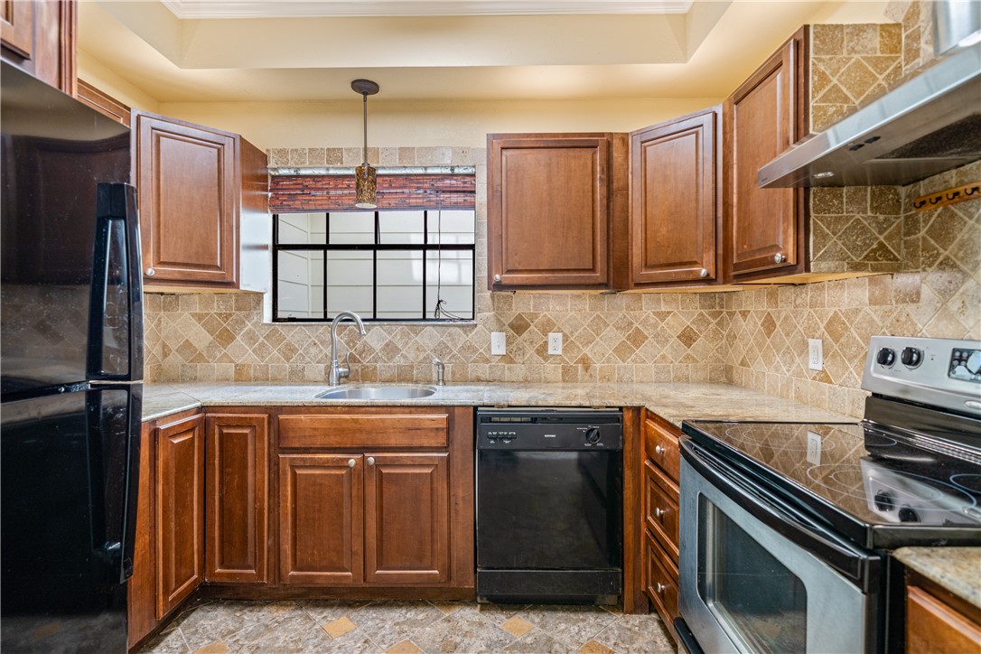 3052 Quail Springs Road, Unit A3 Corpus Christi, TX 78414 - Photo 8 of 27 a kitchen with stainless steel appliances granite countertop a stove a sink and a microwave