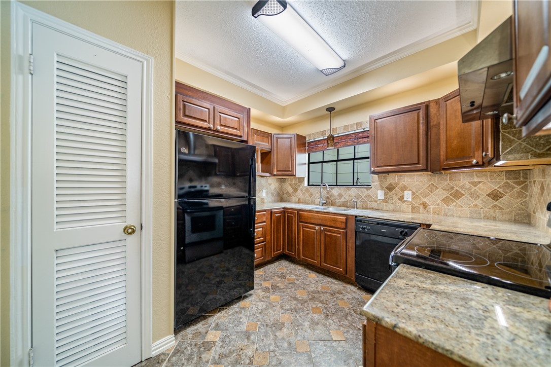 3052 Quail Springs Road, Unit A3 Corpus Christi, TX 78414 - Photo 9 of 27 a kitchen with stainless steel appliances granite countertop a stove sink and cabinets