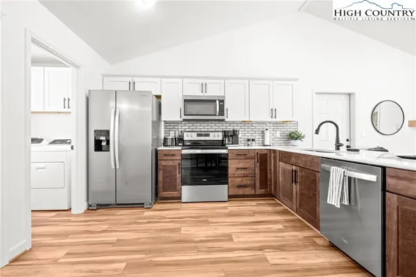 a kitchen with stainless steel appliances kitchen island granite countertop a refrigerator and a stove top oven