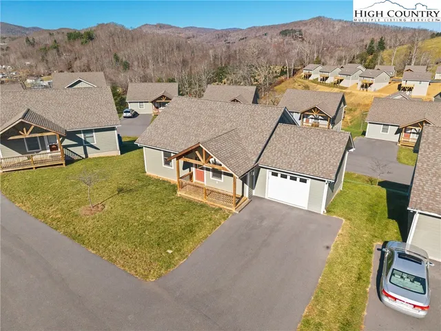 a view of a house with pool and a couple of lawn chairs