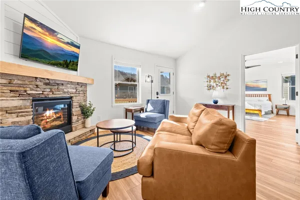 a living room with furniture a flat screen tv and a fireplace