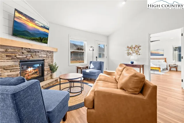 a living room with furniture a flat screen tv and a fireplace