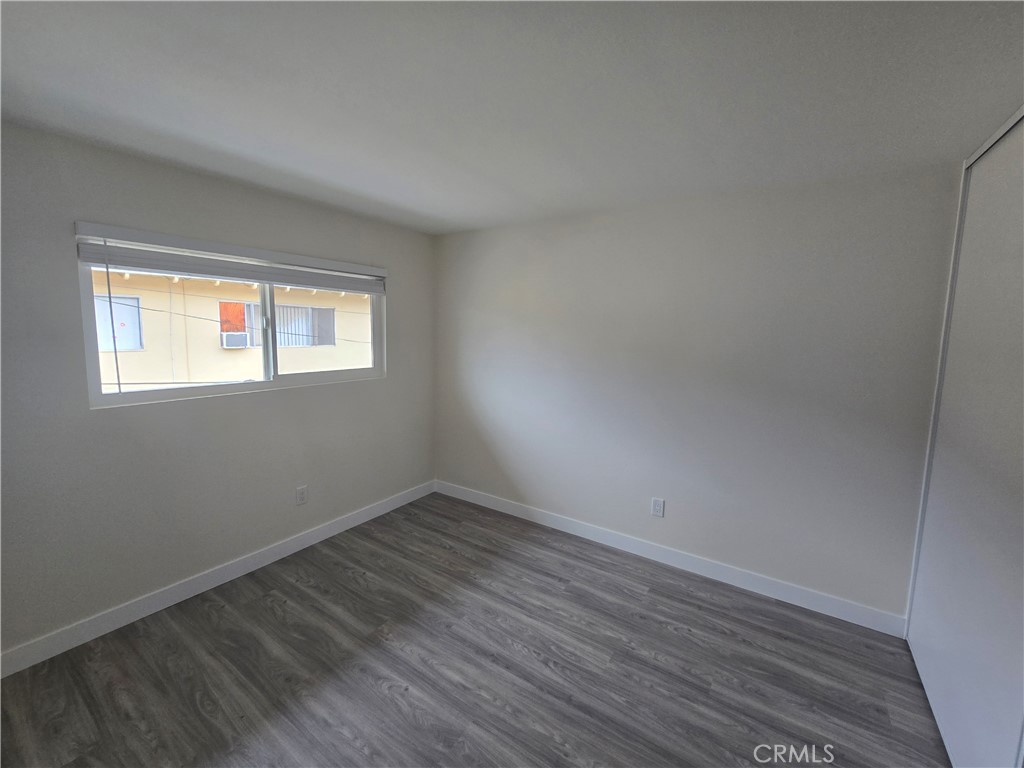 6051 Lemon Avenue, Unit C Cypress, CA 90630 - Photo 4 of 16 a view of an empty room with wooden floor and a window