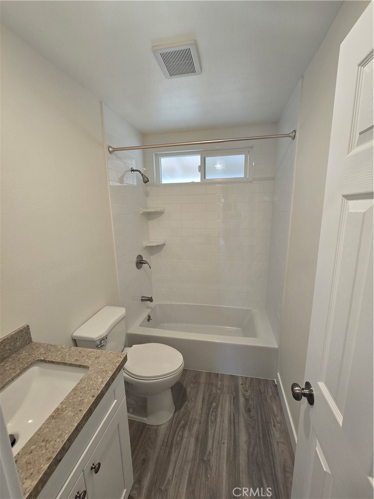 6051 Lemon Avenue, Unit C Cypress, CA 90630 - Photo 9 of 16 a bathroom with a granite countertop toilet a sink and bathtub