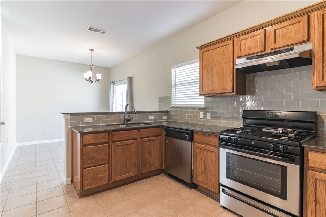 5625 Signal Point Austin, TX 78724 - Photo 5 of 28 Kitchen has granite counter tops. Gas stove. Dining area in background.