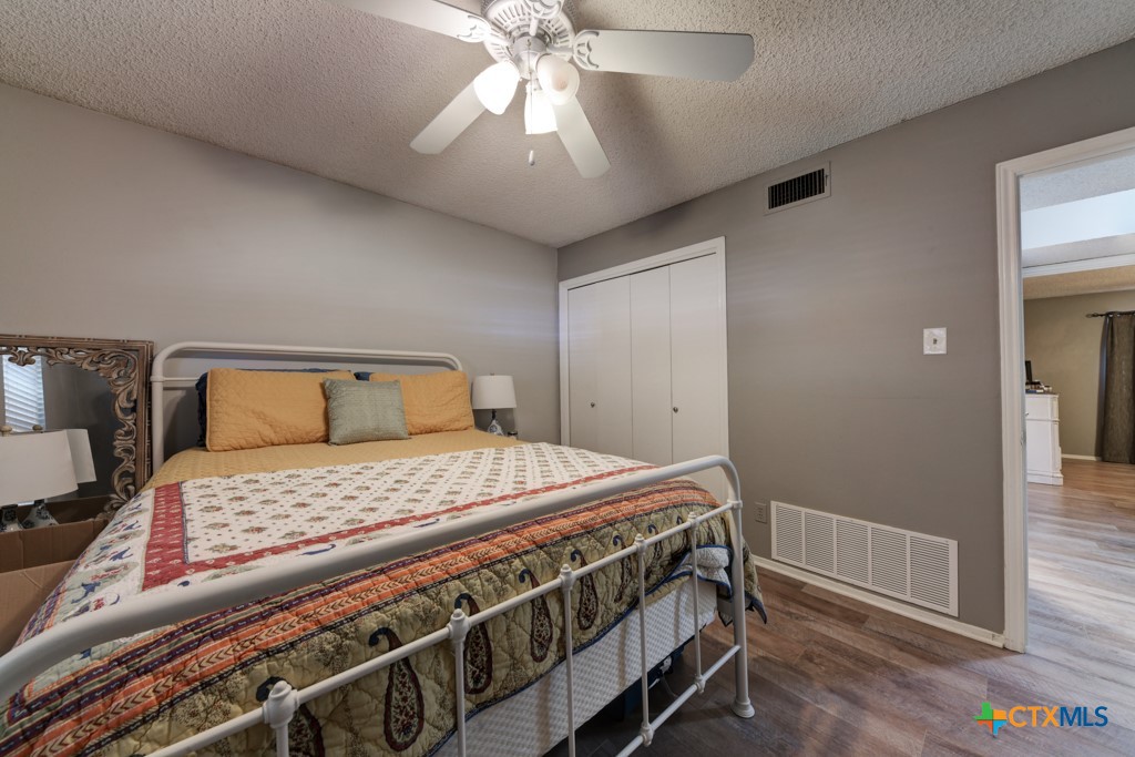 1229 Rapids Road New Braunfels, TX 78130 - Photo 14 of 27 a bedroom with a bed and a chandelier