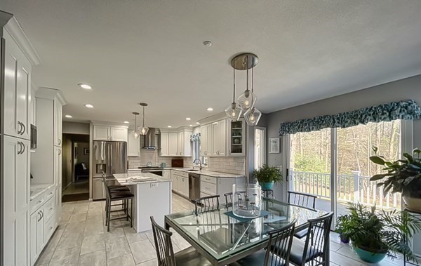 20 Warren Road Wilbraham, MA 01095 - Photo 14 of 41 a kitchen with stainless steel appliances a dining table chairs stove and white cabinets