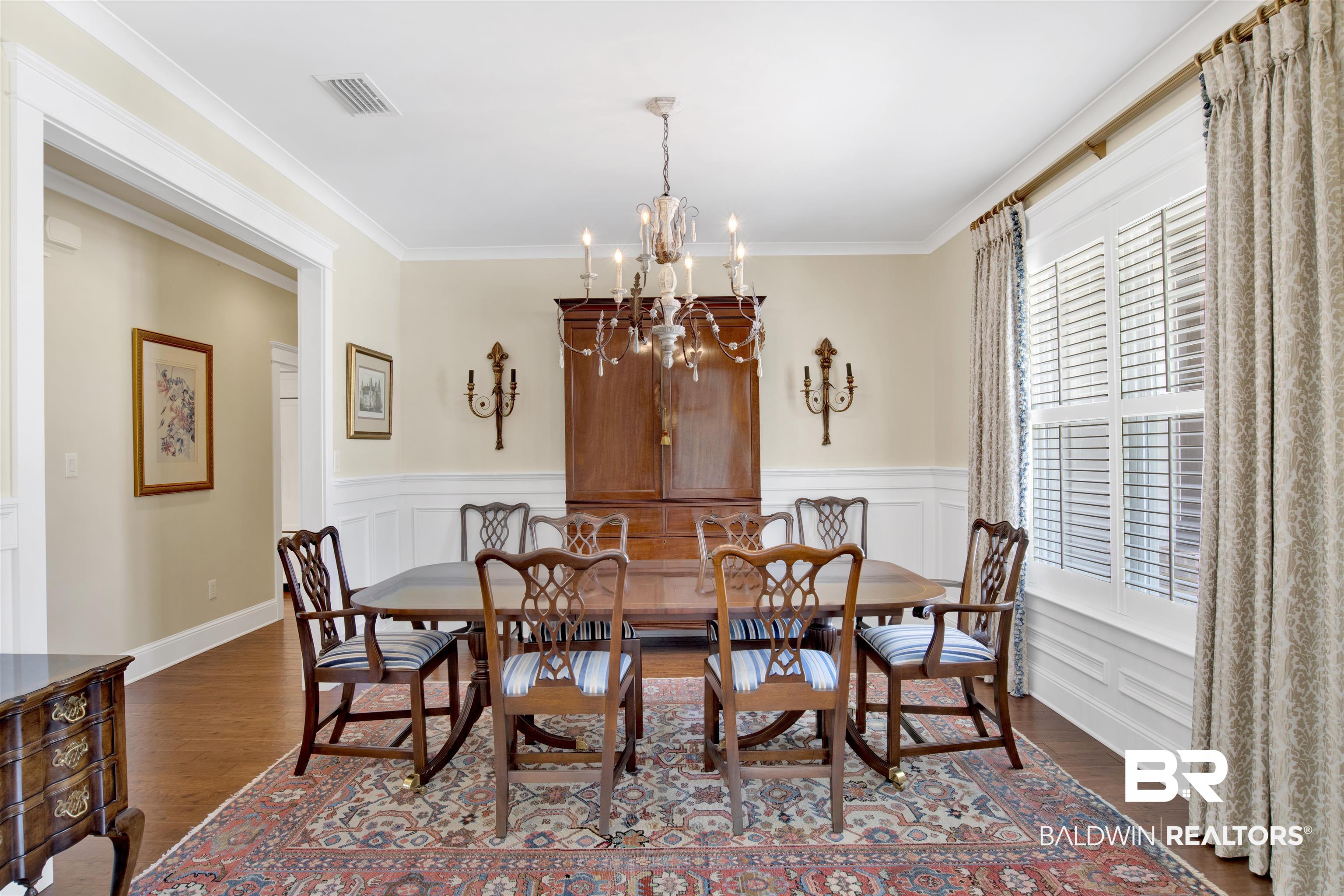 131 Sedgefield Avenue Fairhope, AL 36532 - Photo 9 of 50 Dining space featuring dark wood-type flooring, a notable chandelier, and crown molding