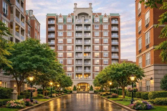 a front view of a building with lot of trees and buildings
