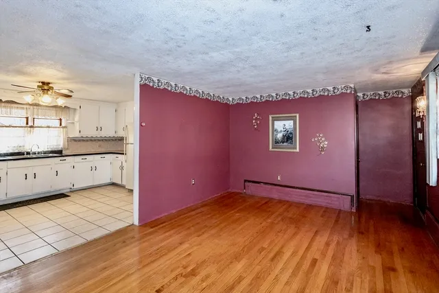 a view of an empty room with window and fire place