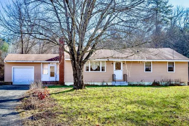 a front view of house with yard and trees