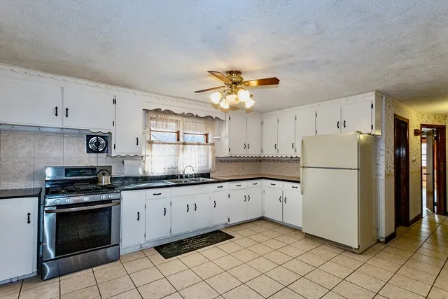 a kitchen with a refrigerator a stove top oven and cabinets