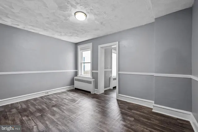 a view of a room with wooden floor and white walls