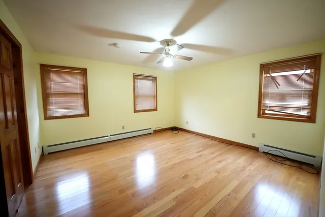an empty room with windows and cabinet