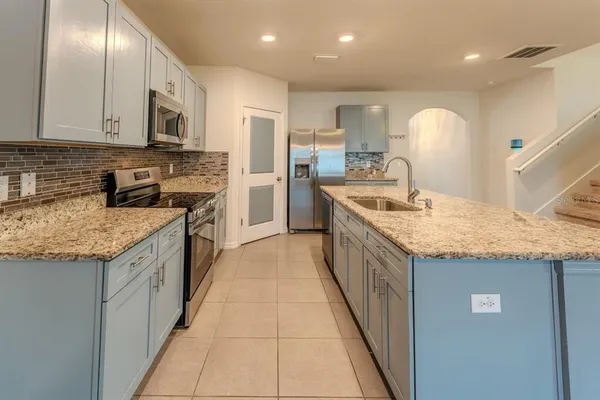 a kitchen with stainless steel appliances granite countertop a sink and dishwasher a stove top oven with wooden floor