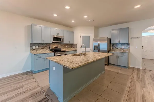 a kitchen with stainless steel appliances granite countertop a stove a sink and a refrigerator