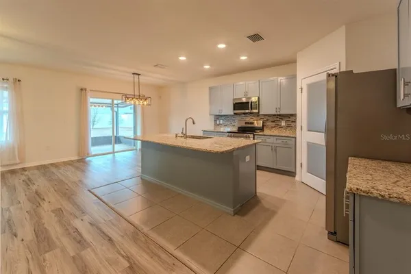 a kitchen with stainless steel appliances granite countertop a refrigerator and a stove