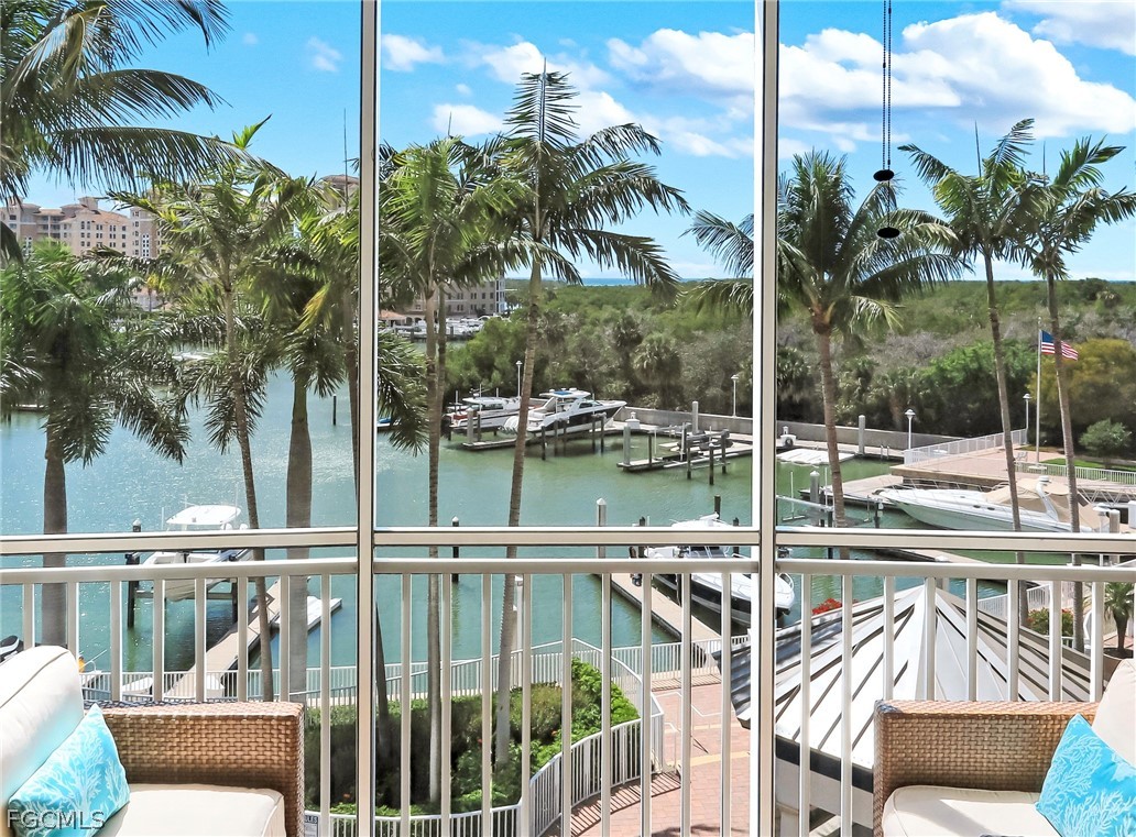 13675 Vanderbilt Drive, Unit 406 Naples, FL 34110 - Photo 12 of 43 a view of a swimming pool with a table and chairs