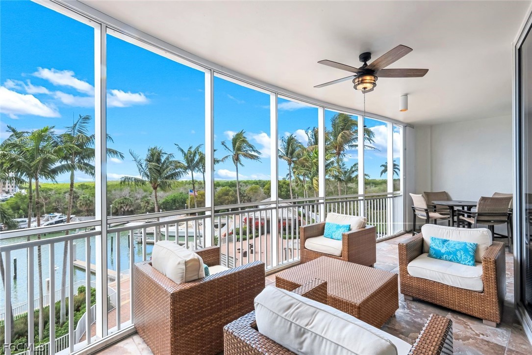 13675 Vanderbilt Drive, Unit 406 Naples, FL 34110 - Photo 13 of 43 a living room with furniture and a large window