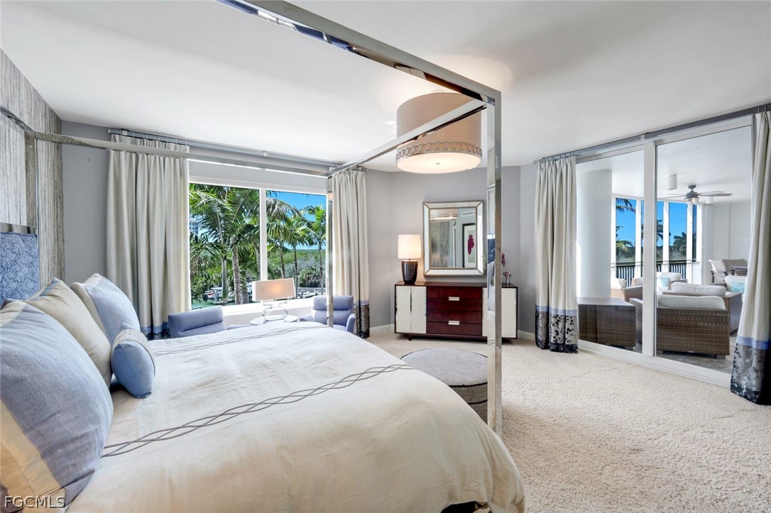 13675 Vanderbilt Drive, Unit 406 Naples, FL 34110 - Photo 17 of 43 a bedroom with a bed couch and three large window