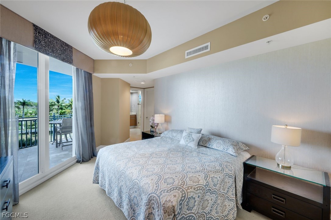 13675 Vanderbilt Drive, Unit 406 Naples, FL 34110 - Photo 22 of 43 a bedroom with a bed and a lamp