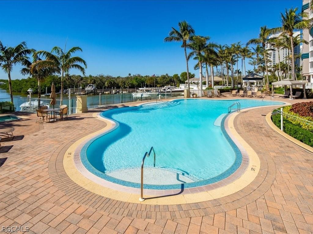 13675 Vanderbilt Drive, Unit 406 Naples, FL 34110 - Photo 32 of 43 a view of a swimming pool with a patio