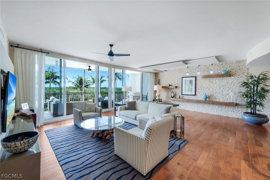 13675 Vanderbilt Drive, Unit 406 Naples, FL 34110 - Photo 6 of 43 a living room with furniture and a large window