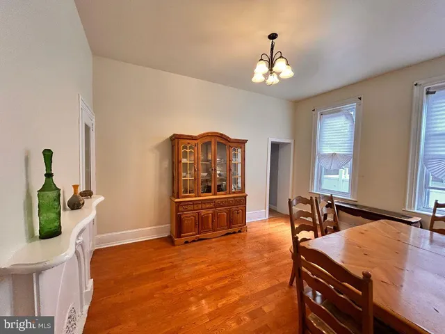a dining room with wooden floor and chandelier
