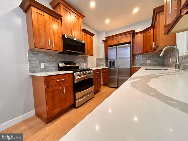a kitchen with stainless steel appliances a stove a sink and a microwave