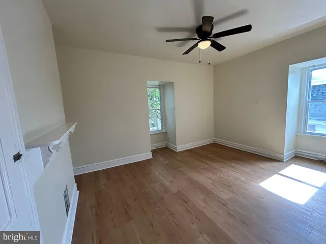wooden floor in an empty room with a window