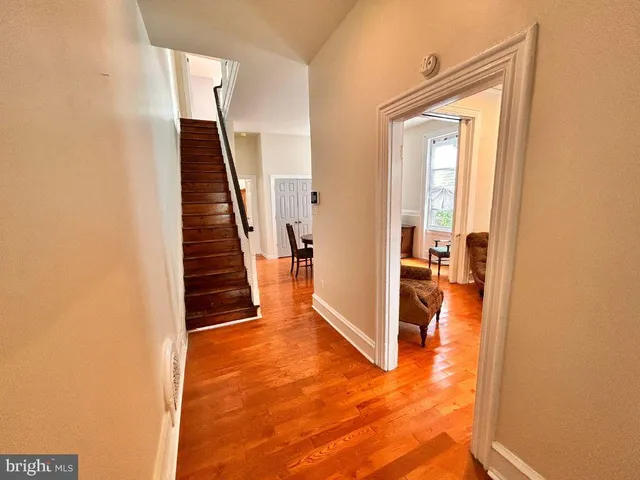 a view of a hallway with wooden floor and entryway