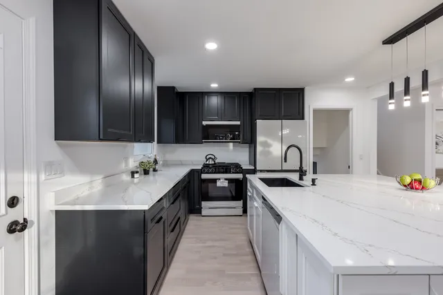 a kitchen with a stove sink and cabinets