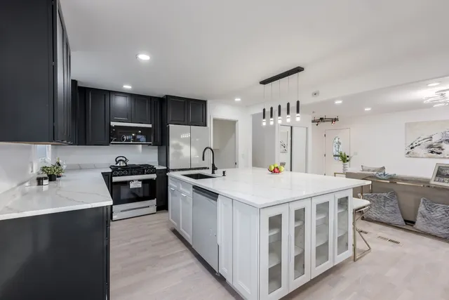 a kitchen that has a lot of cabinets in it and wooden floors