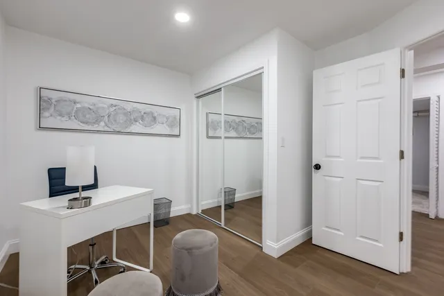 a view of a hallway with wooden floor and stairs