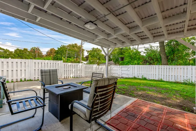 a view of a backyard with furniture and garden